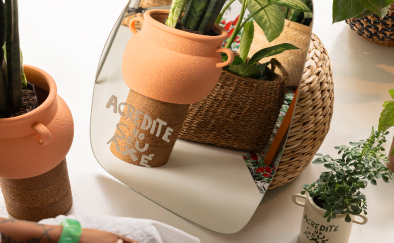 espelho para sala de jantar em um formato orgânico para complementar a decoração, além de diversos vasos com plantas para deixar o ambiente mais aconchegante.