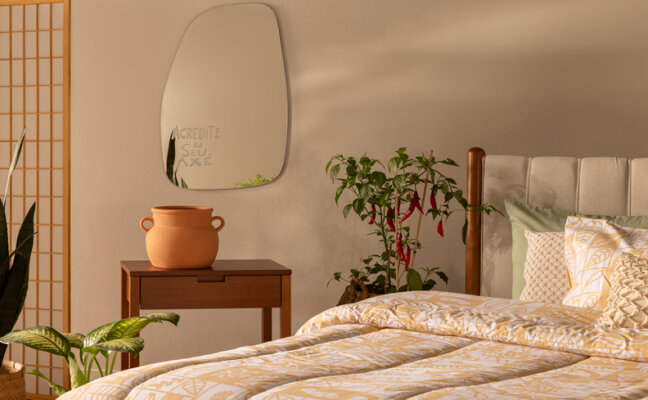 dicas para saber como deixar o quarto mais fresco e aconchegante com roupa de cama leve, plantas, espelho e vaso decorativo.