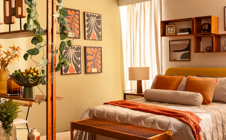 quarto com roupa de cama casal algodão para ajudar a manter o ambiente mais fresco, além de plantas, quadros, cortinas e itens decorativos para deixar o ambiente confortável e aconchegante.