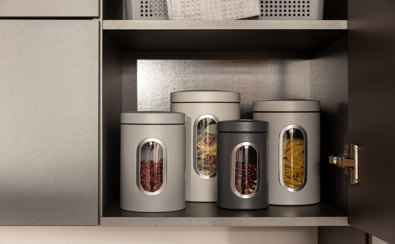 kit potes herméticos de aço na cor cinza dentro do armário da cozinha para conservar os alimentos e deixar tudo mais organizado.