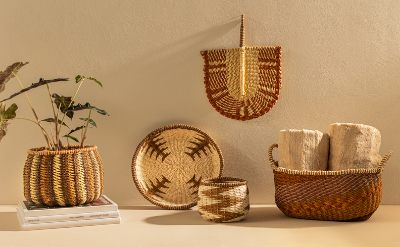 plantas tóxicas para cães para evitar ter em casa em um ambiente com diversos cestos de palha com plantas, um cesto com toalhas e itens decorativos para complementar a decoração.