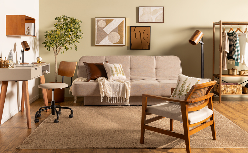 sofá para sala pequena e estreita com um sofá cama, poltrona, escrivaninha, cadeira de escritório, quadros decorativos e nichos com itens de decoração.