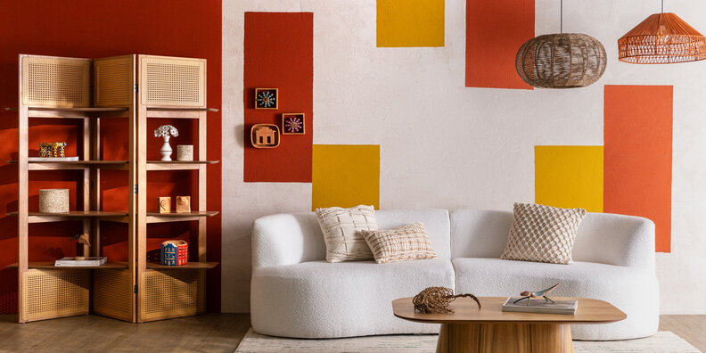 artesanato na decoração em uma sala de estar com sofá, tapete, almofadas, lustres pendentes, estante e diversos adornos de artesanato de diversas regiões do Brasil.