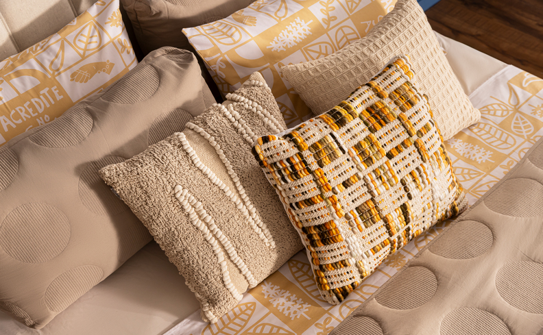 como fazer cama posta com diversas almofadas, travesseiros, roupas de cama como lençol, edredom e peseira em cores neutras para ser mais fácil de fazer as composições.