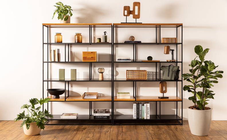 escritório corporativo com estante grande com diversos itens decorativos de escritório e vasos de plantas.