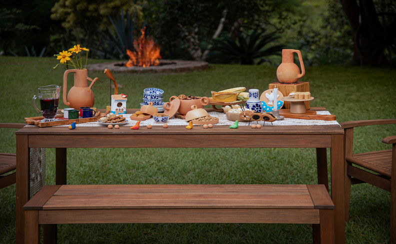 ideias de brincadeiras para festa junina em casa com mesa retangular com diversas comidas da época para deliciar os convidados.