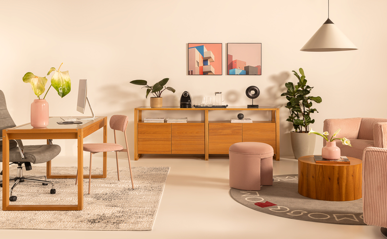 recepção de escritório corporativo com sofás, puffs, armários, mesa, cadeira e diversos itens decorativos.