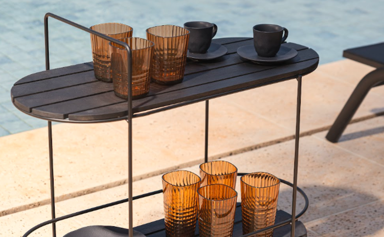 carrinho bar metal na área externa da casa próximo a piscina para tomar as bebidas com mais facilidade, carrinho com copos, xícaras e pratos para deixar tudo mais prático na hora de servir.