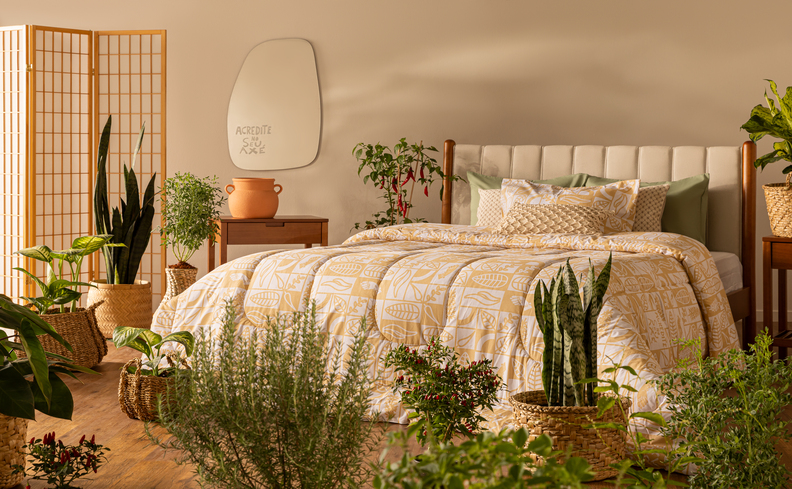 biombos para separar ambientes no quarto com biombo de madeira vazado, cama com edredom branco, travesseiros, cabeceira, espelho e diversos vasos com plantas.