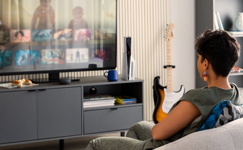 atividade para o dia dos pais em casa com direito a uma noite de cinema em casa na sala de estar com a filha sentada no sofá procurando um filme para assistir com o pai.