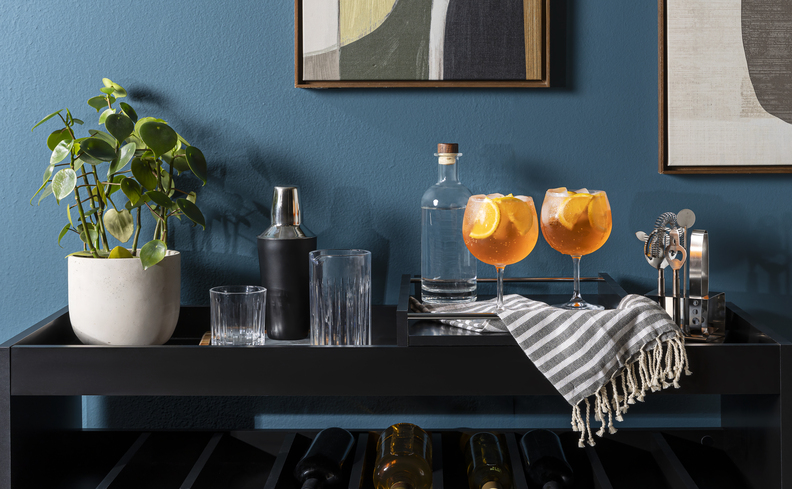 coisas para fazer no dia dos pais na sala de estar com buffet, bandeja organizadora, coqueteleira, taças com drinks, garrafa de bebidas e copos para ter uma tarde preparando drinks com os pais.