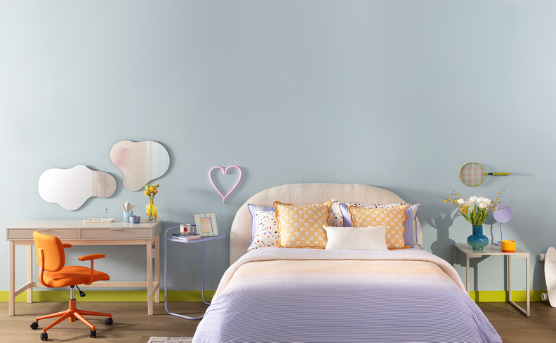 cabeceira de cama casal e queen size em um quarto amplo com cabeceira branca redonda, cama com roupas de cama em tons de azul e rosa claro, além de penteadeira, cadeira e espelhos.